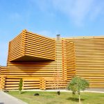 A museum with a stacked timber facade that illustrates modern sustainable building design